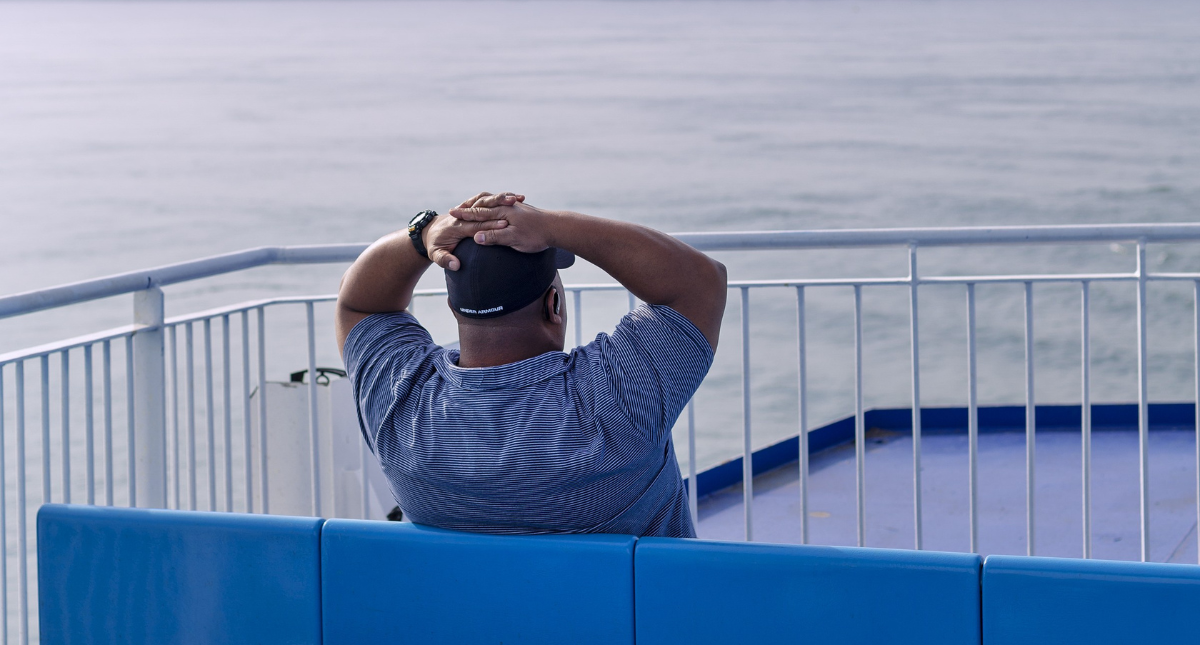 Man sitting on the deck of the Wightlink ferry, Isle of Wight